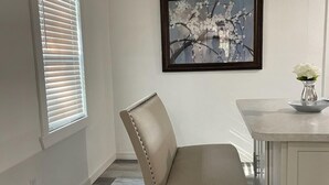 A dining area with a chair, a table, and a framed artwork on the wall. - Charming City Bungalow (Jacksonville)