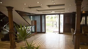 A spacious lobby with a patterned floor, a staircase, and a large potted plant. - River Boat - Double Room with Private Bathroom (Cairo)