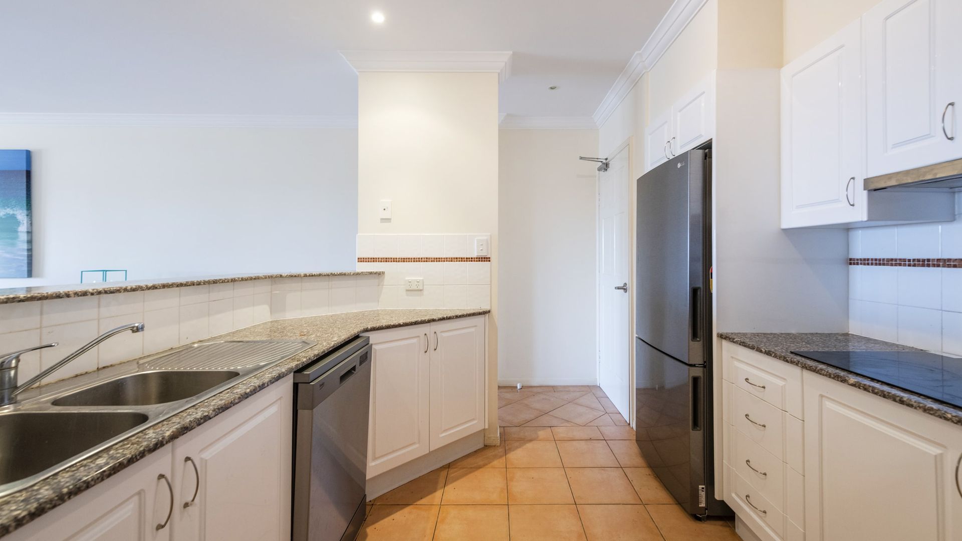 A modern kitchen with granite countertops, stainless steel appliances, and white cabinetry.