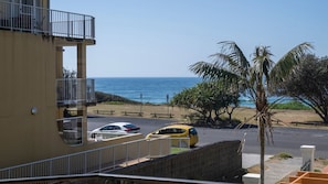 Vista costera con un edificio, una carretera y una playa.