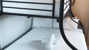A bunk bed with white bedding and a rolled towel on the lower bunk. - Seaspray 8 - Stone Real Estate Yamba (Yamba)
