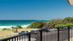 A coastal view with a beach, ocean, and parked cars. - Edgewater 1- Ocean Views- Stone Real Estate Yamba (Yamba)