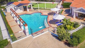A residential property with a swimming pool, a tennis court, and a covered patio area. - Peninsula Court 6- Stone Real Estate Yamba (Yamba)