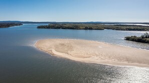 A river with a sandy beach and forested islands.