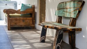 A wooden bench with a distressed finish, positioned against a wall. - Kailani Beach House - Stone Real Estate Yamba (Yamba)