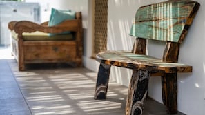 A wooden bench with a distressed finish, positioned against a wall. - Kailani Beach House - Stone Real Estate Yamba (Yamba)