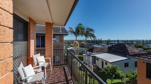 A balcony with outdoor furniture, a view of neighboring houses, and a clear sky. - Elsewhere 3- Stone Real Estate Yamba (Yamba)