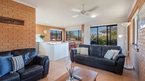 A living area with a sofa, a coffee table, and a kitchen in the background.