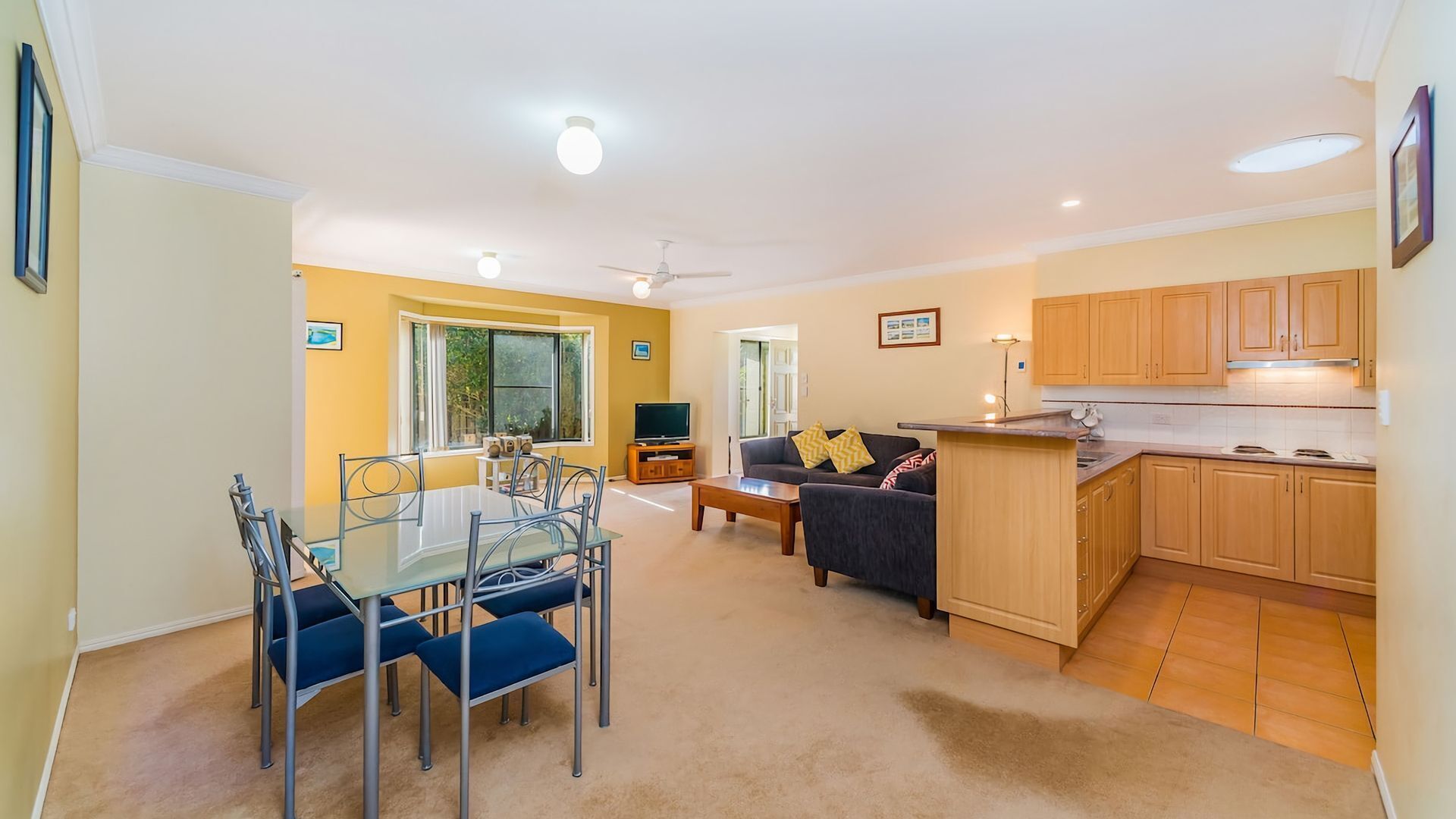 A compact living space with a dining area, sofa, and kitchenette.