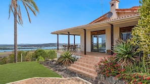 A house with a patio, a view of a body of water, and a garden with cacti and flowers. - Casa Del Rio- Stone Real Estate Yamba (Ashby Heights)