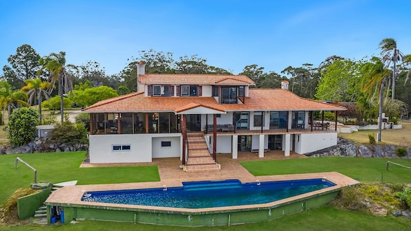 A two-story house with a large front yard, a swimming pool, and a covered outdoor area. - Casa Del Rio- Stone Real Estate Yamba (Ashby Heights)