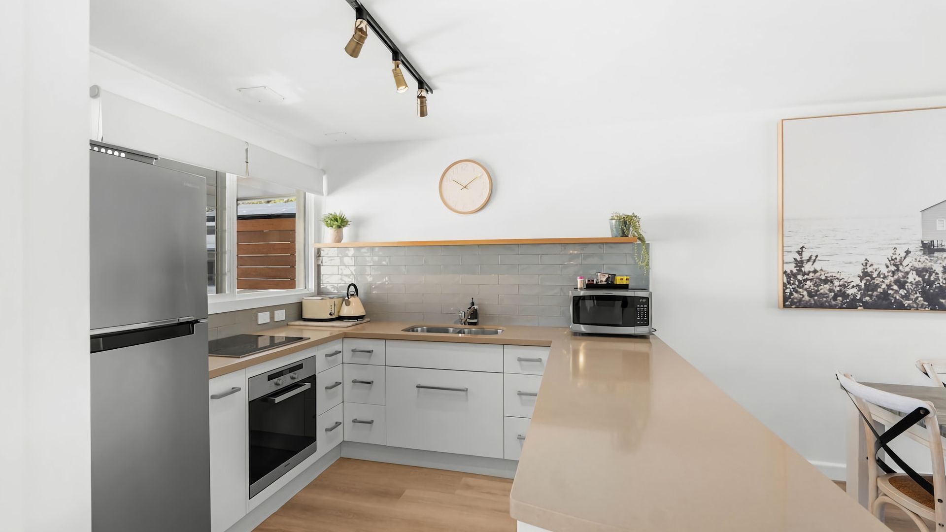 Una cocina moderna equipada con refrigerador, horno, microondas y pileta.