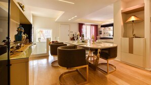 A modern kitchen with a dining area, wooden flooring, and contemporary furniture.