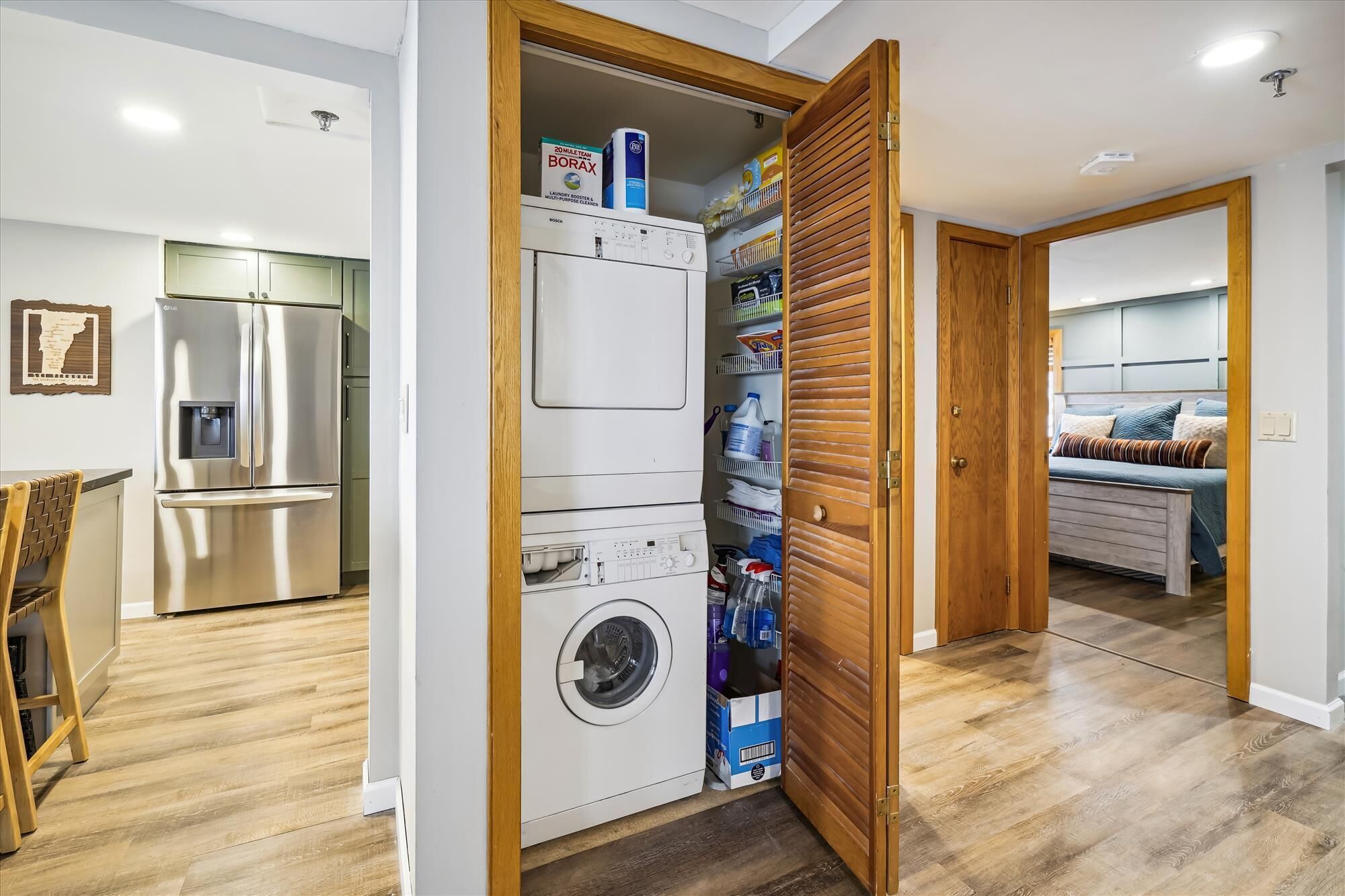 Une petite buanderie équipée d’un lave-linge, d’un sèche-linge et d’étagères de rangement.