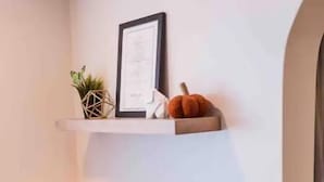 A white desk with a radio, a small plant, and a pumpkin on a shelf. - Cool, Trendy house in Dodge City! The Painted Cow (Dodge City)