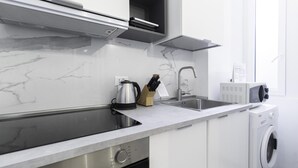 A modern kitchen with a stainless steel sink, a kettle, and a microwave. - Italianway Easy - Ozieri 7 (Milan)