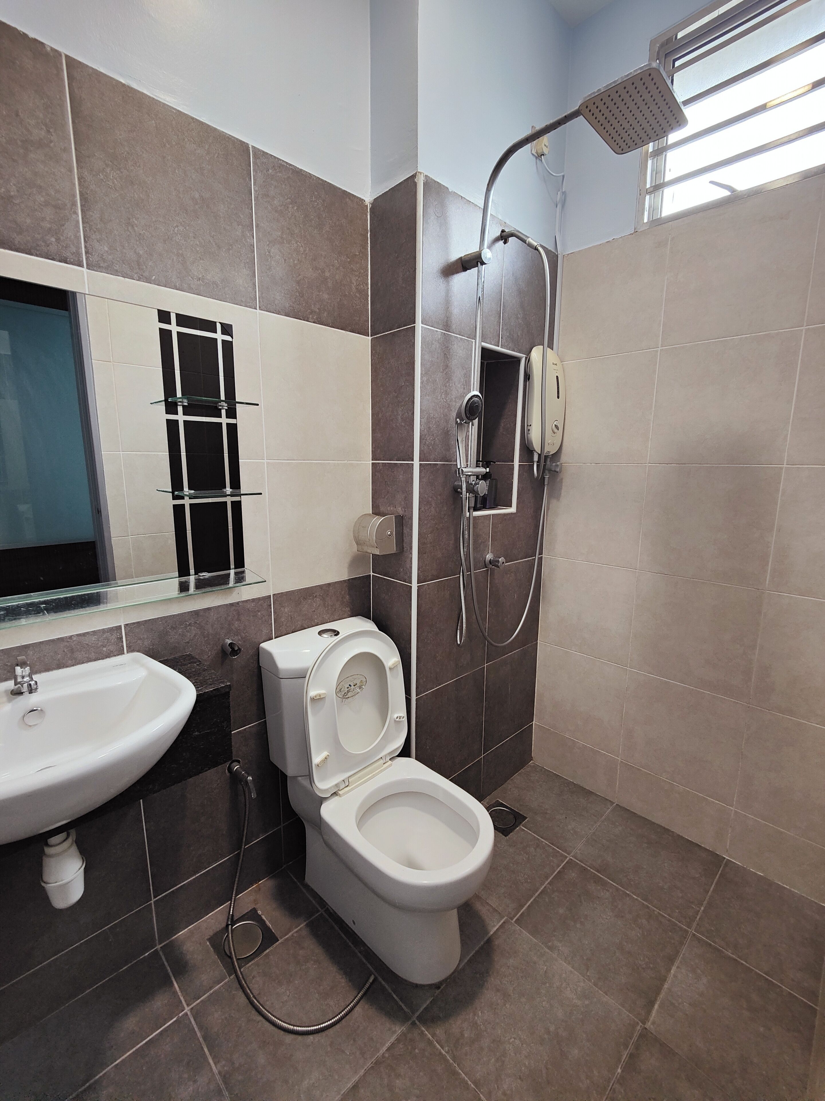 A modern bathroom with a toilet, sink, and shower.