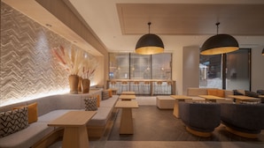 Een moderne zithoek met een bank, tafels en stoelen.