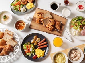 A breakfast buffet with various dishes including croissants, scrambled eggs, sausages, and a salad. - the b sapporo (Sapporo)