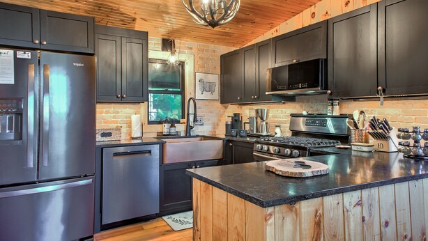 A modern kitchen with stainless steel appliances, wooden cabinets, and a large island.