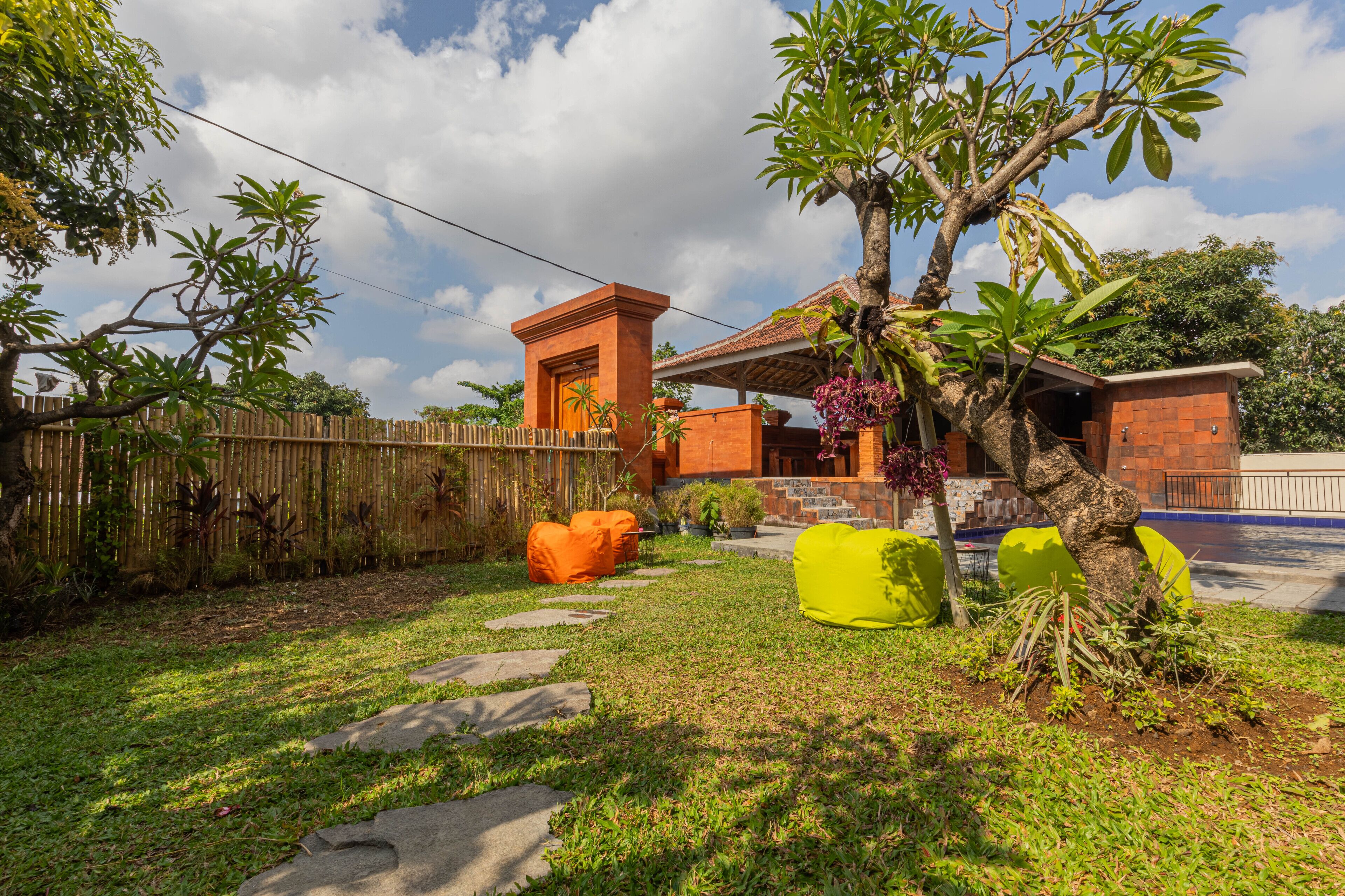 Una propiedad residencial con patio trasero cercado, una pequeña construcción de ladrillo y mobiliario exterior.