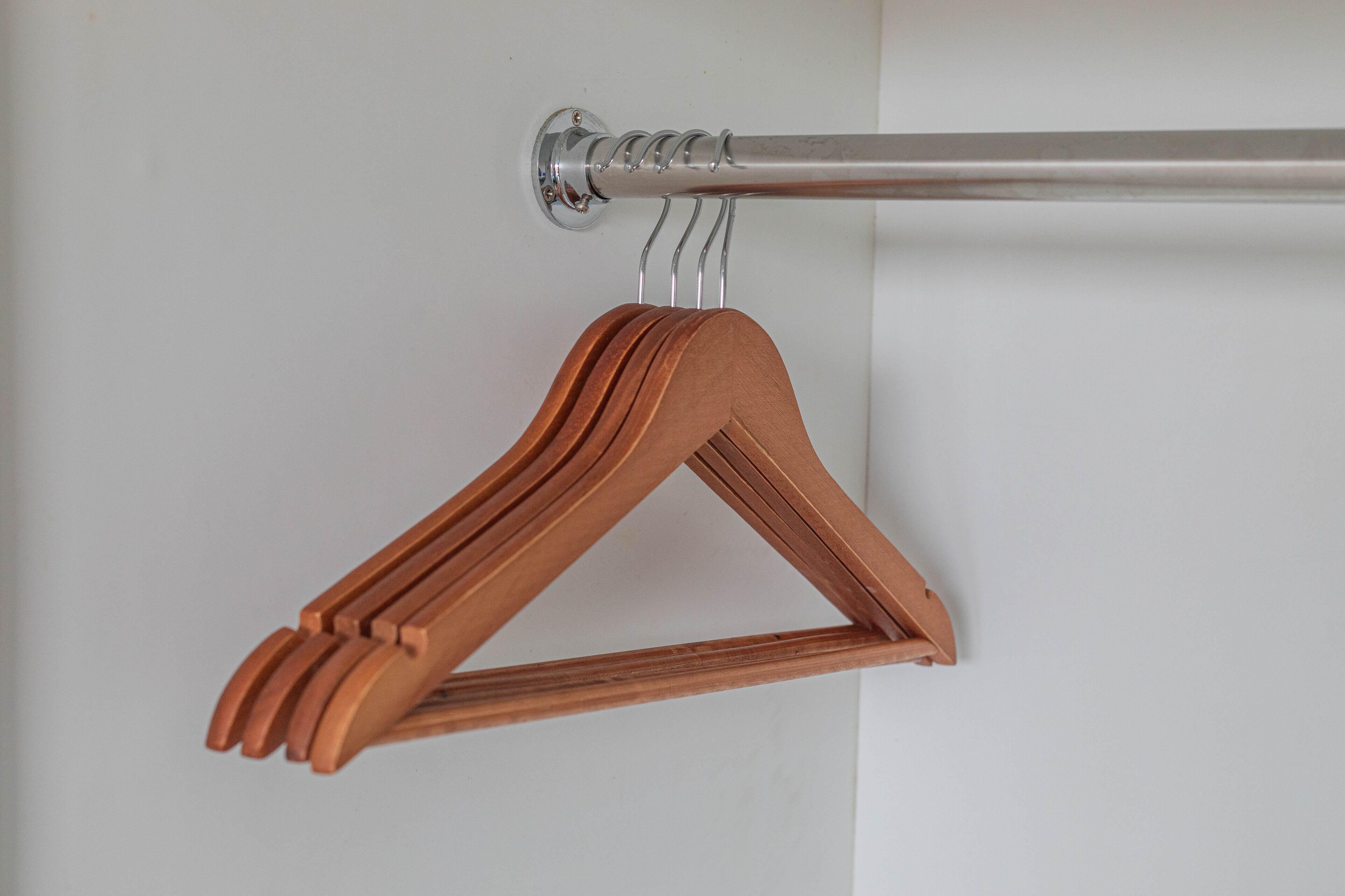 Une tringle à rideaux en métal, munie d’un support en bois.