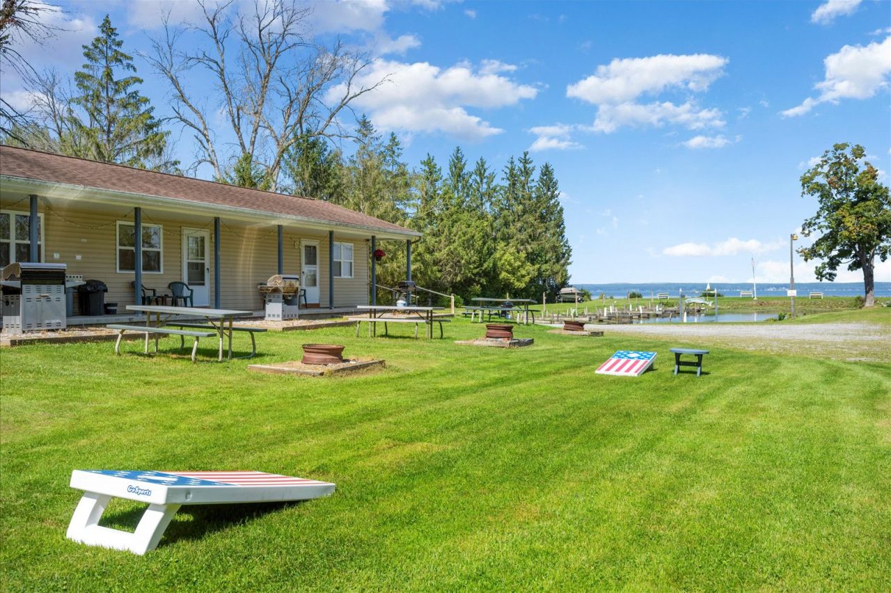 Un'area esterna curata con un edificio, tavoli da picnic e una piccola bandiera americana sull'erba.