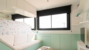 Un espacio habitable moderno y funcional, con un sofá, una mesita y un televisor.