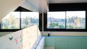 Una habitación con cama, ventana y vista al paisaje.