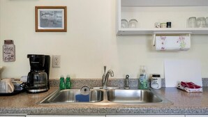 A kitchen with a double sink, coffee maker, and various kitchen items on the counter. - Hidden Harbor Marina, The Entire Property (Sleeps 16) - Oneida Lake's Premier Fishing Getaway (Canastota)