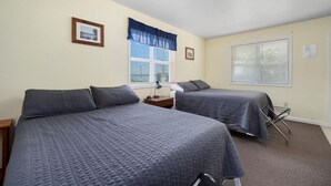 A bedroom with two beds, a nightstand, a lamp, and a window with blinds. - Hidden Harbor Marina, The Entire Property (Sleeps 16) - Oneida Lake's Premier Fishing Getaway (Canastota)