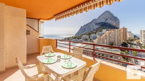 A balcony with a table set for two, overlooking a coastal cityscape with a prominent mountain in the background. - Zafiro 211B - Grupo Turis - Calpe, Costa Blanca (Calpe)