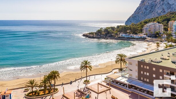 A coastal hotel with a beach view, a parking area, and a mountainous backdrop. - Zafiro 211B - Grupo Turis - Calpe, Costa Blanca (Calpe)