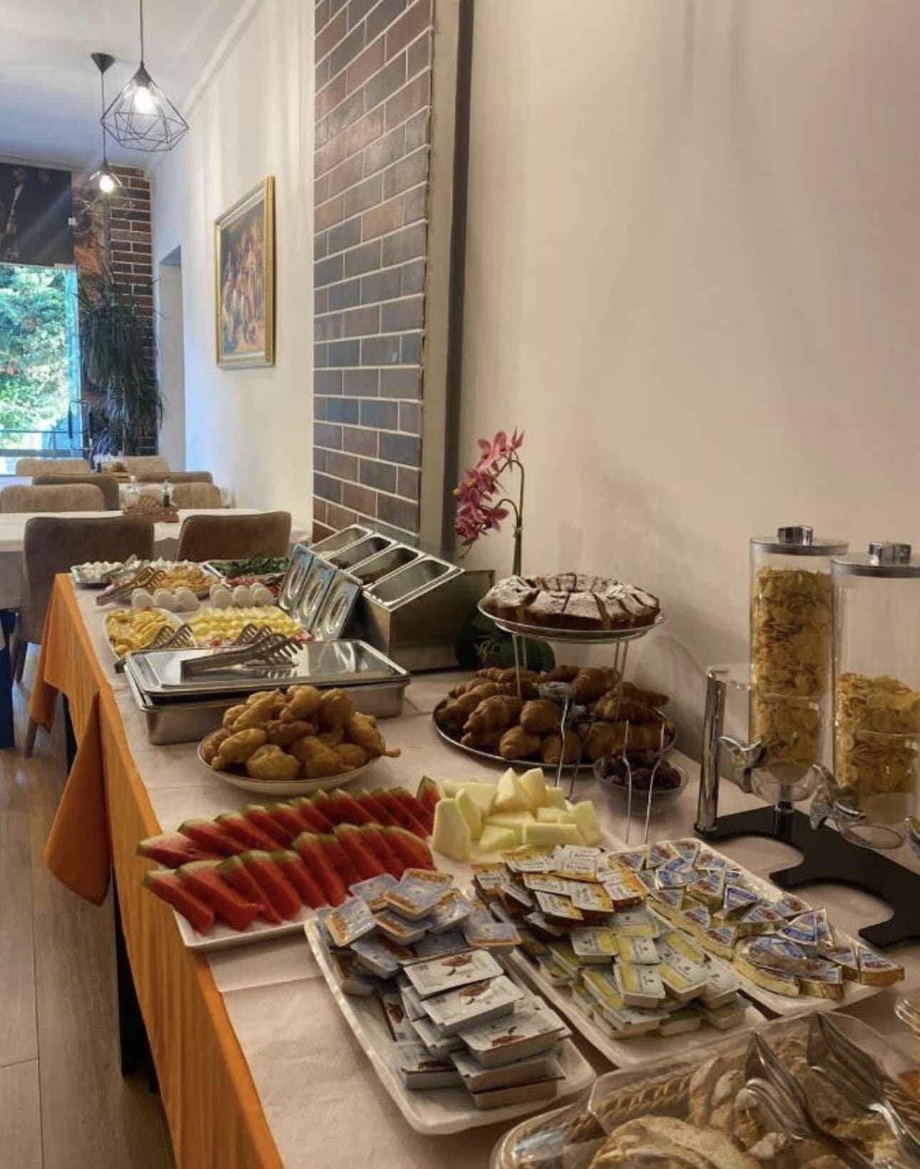 Un buffet proposant une variété de plats, notamment des fruits, des pâtisseries et des fromages.