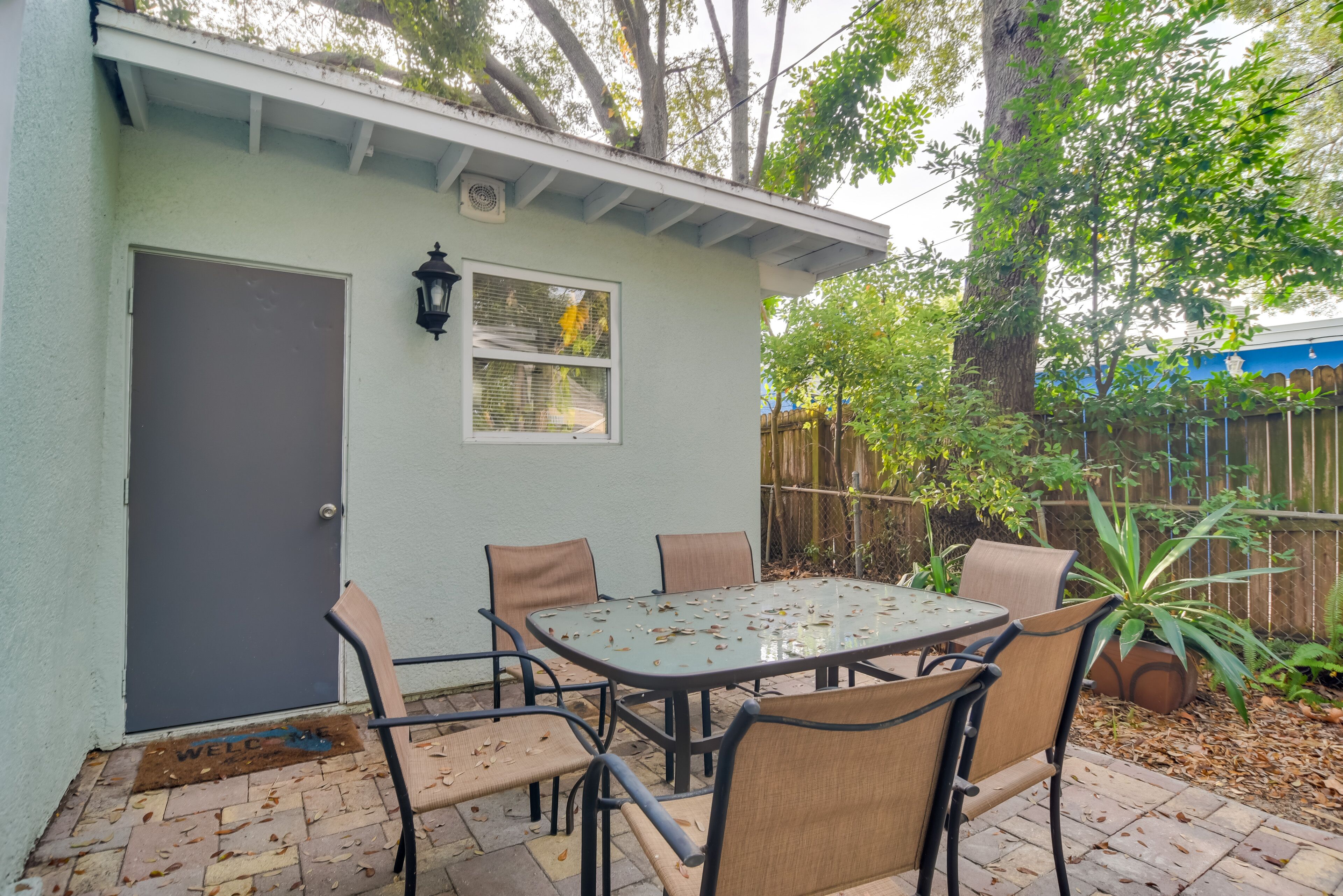 A patio with a table and chairs, a door, and a window.