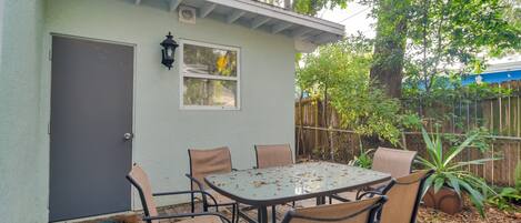A patio with a table and chairs, a door, and a window.