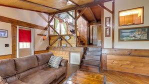 A wooden interior with a staircase, a leather sofa, and a dining table. - Mountaintop Ellijay Cabin w/ Private Hot Tub (Ellijay)