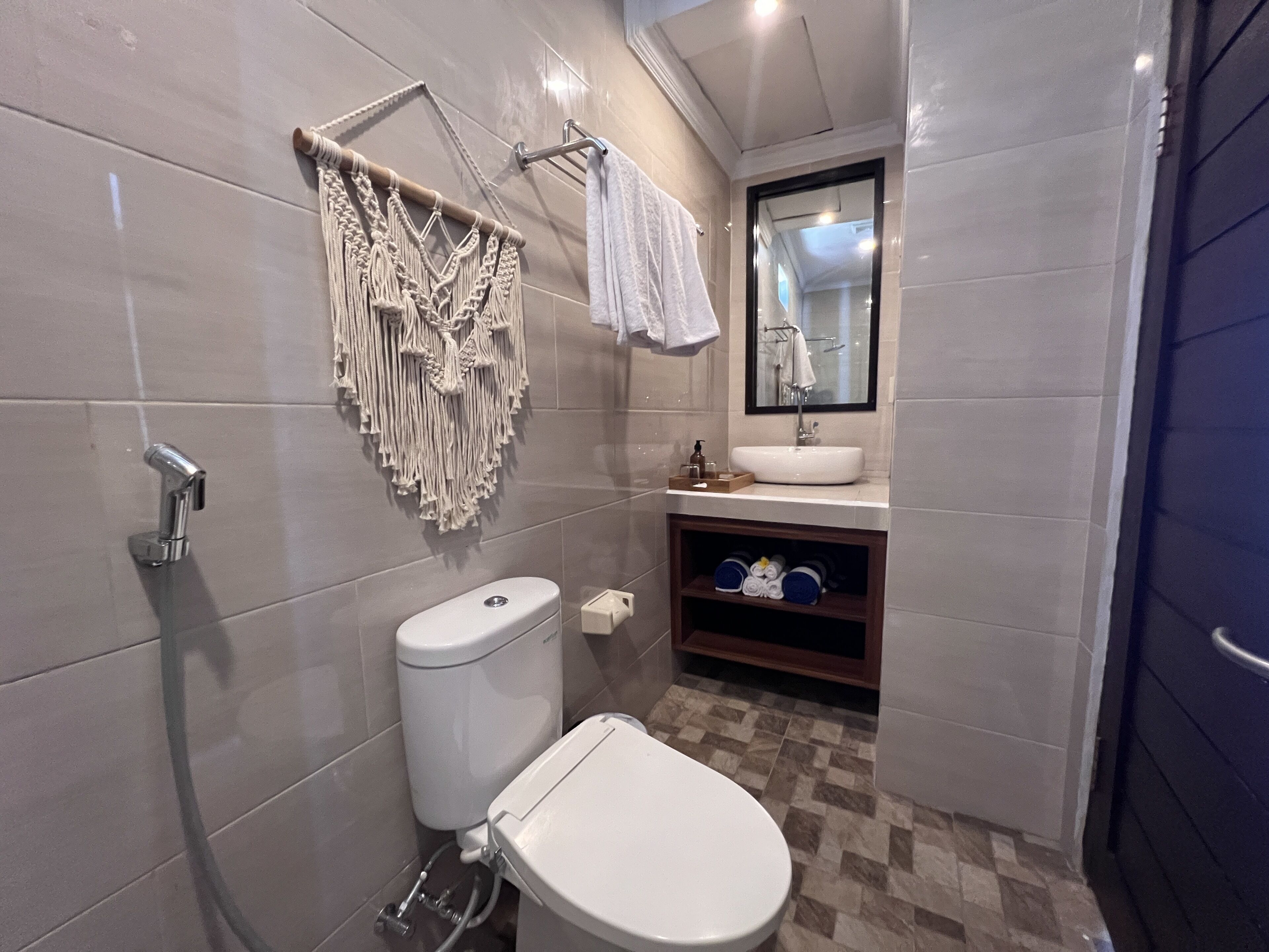 Un baño pequeño con inodoro, lavamanos y toallero.