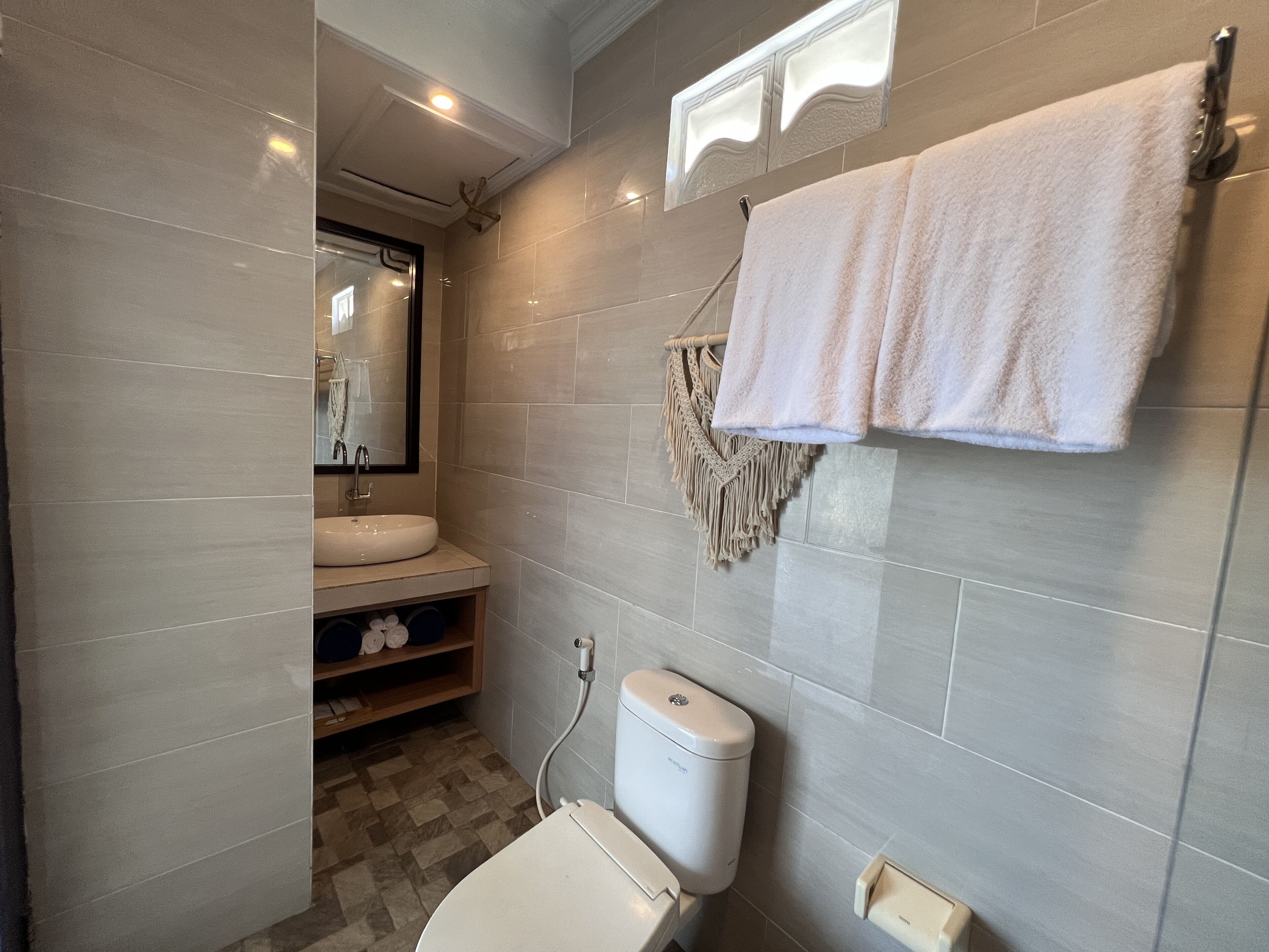 A bathroom with a toilet, sink, and towel rack.