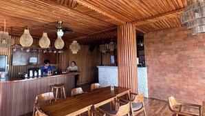 Un restaurante con techo de madera, zona de bar y mesa con sillas.