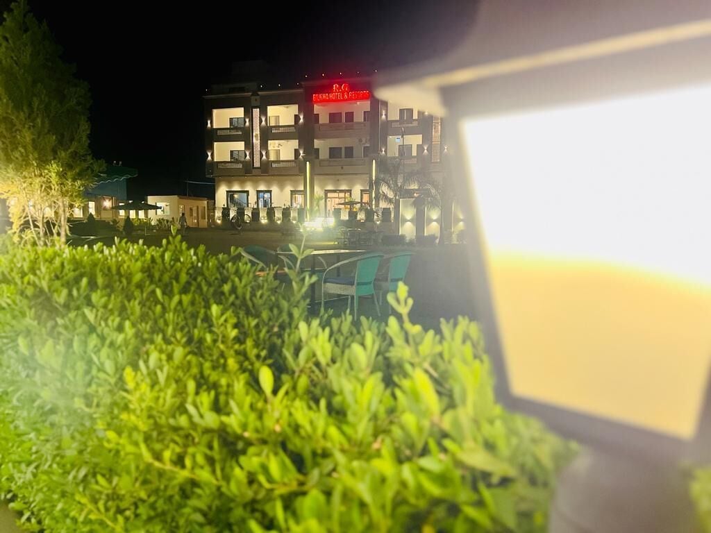 A multi-story hotel with a visible entrance and a parking area.