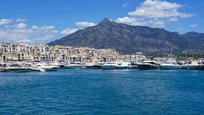A marina with boats docked, a coastal town with white buildings, and mountains in the background. - Fuente Aloha by Interhome (Marbella)