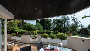 An outdoor dining area with a table set for four, surrounded by chairs, under a covered patio. - Fuente Aloha by Interhome (Marbella)