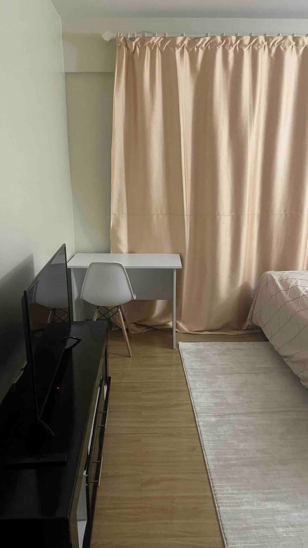 Una habitación pequeña y ordenada con escritorio, silla y cama.