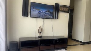 A flat-screen TV mounted on a wall above a dark wooden entertainment center.