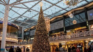 A large indoor shopping mall with a prominent Christmas tree and modern architecture. - Elegant Studio: Studio Suite 5 (Coventry)
