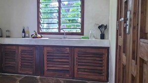 A kitchen with a window, a sink, and wooden cabinets.