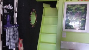 A room with a black wall, a green cabinet, and a window with a view of trees. - TIny House experience, Lake Rotoiti, Rotorua (Rotoiti Forest)