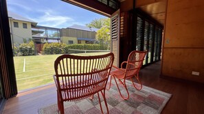 Relax in comfort with a view of the tennis court from the room's large window.