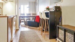 A compact living space with a kitchenette, dining area, and a small seating area with a sofa and chairs.